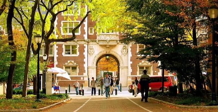 Students crossing a brick college quad in fall, where boarding school graduates go on to enroll
