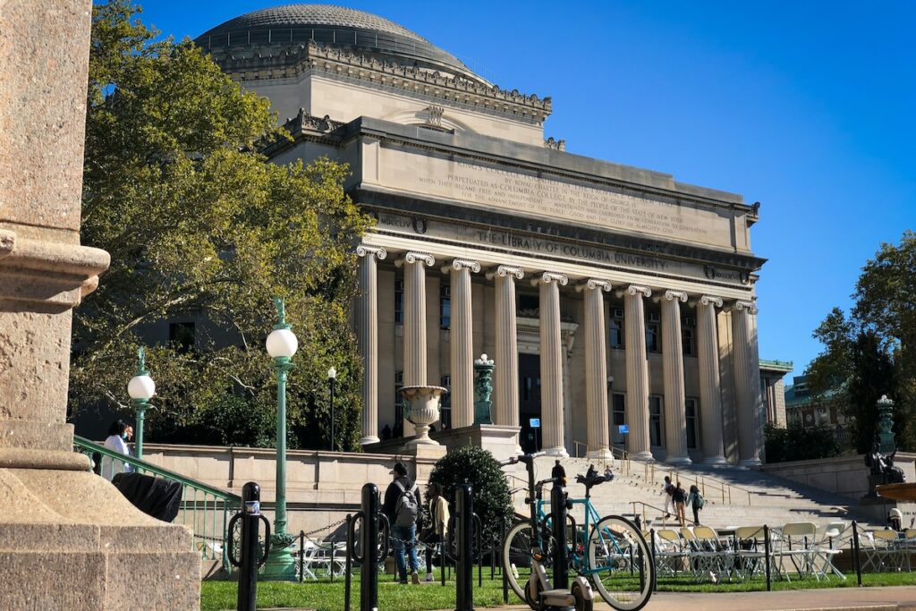 exterior of columbia university with bicycle and students in the foreground