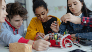 Four students work on a high school robotics and coding project